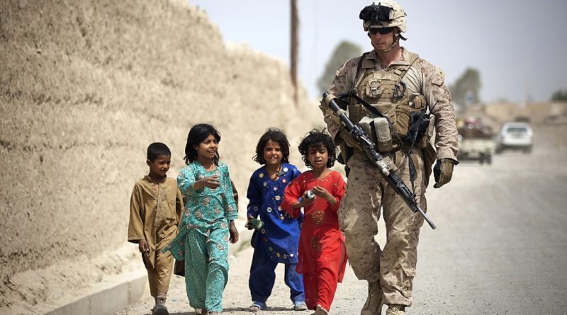 Gruppe afghanischer Kinder mit American Marine auf Streifendienst zu Fuß